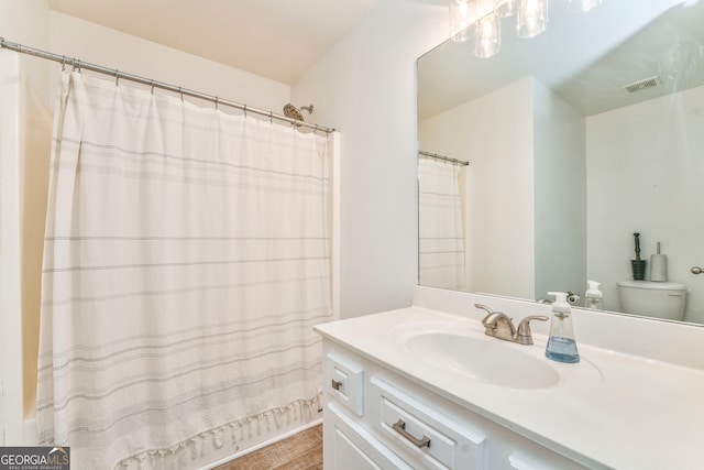 bathroom featuring vanity, hardwood / wood-style flooring, and toilet