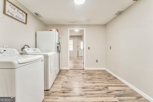 laundry area featuring light wood-type flooring and washer and clothes dryer