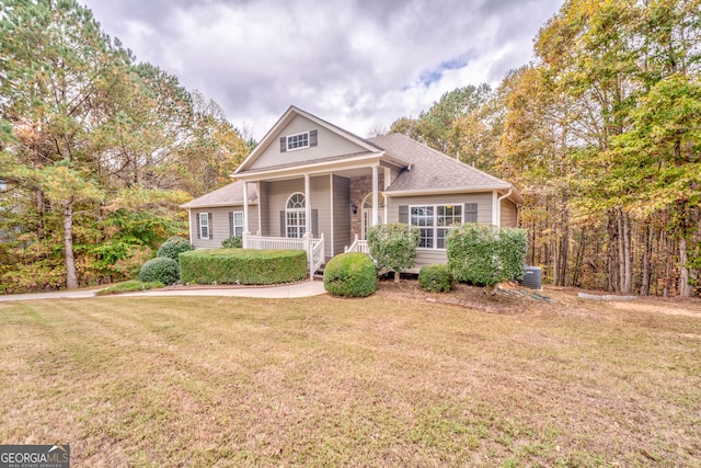 view of front of home with a front lawn, cooling unit, and a porch