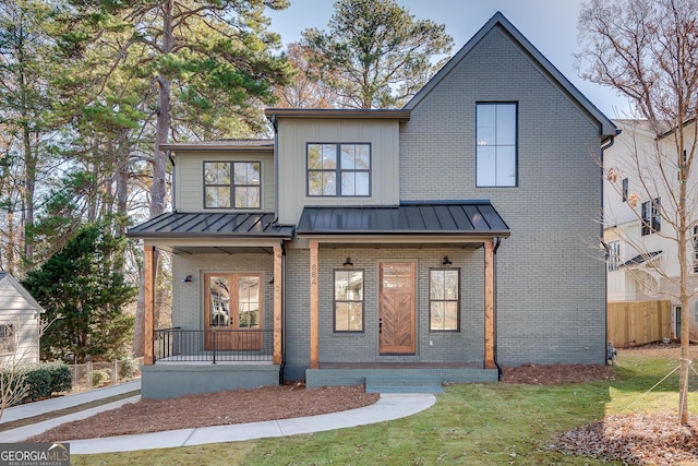 modern farmhouse style home featuring a front lawn and a porch