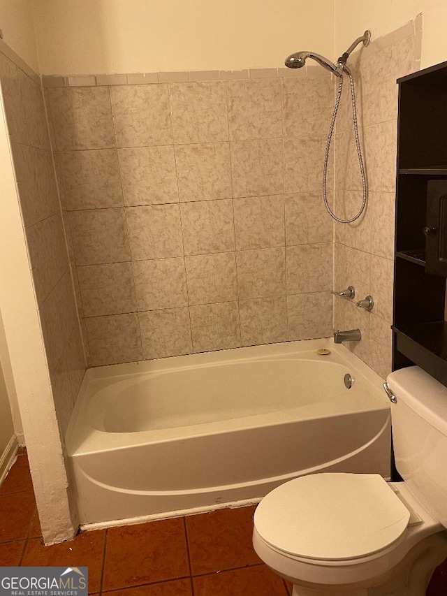 bathroom featuring toilet, tiled shower / bath combo, and tile patterned floors