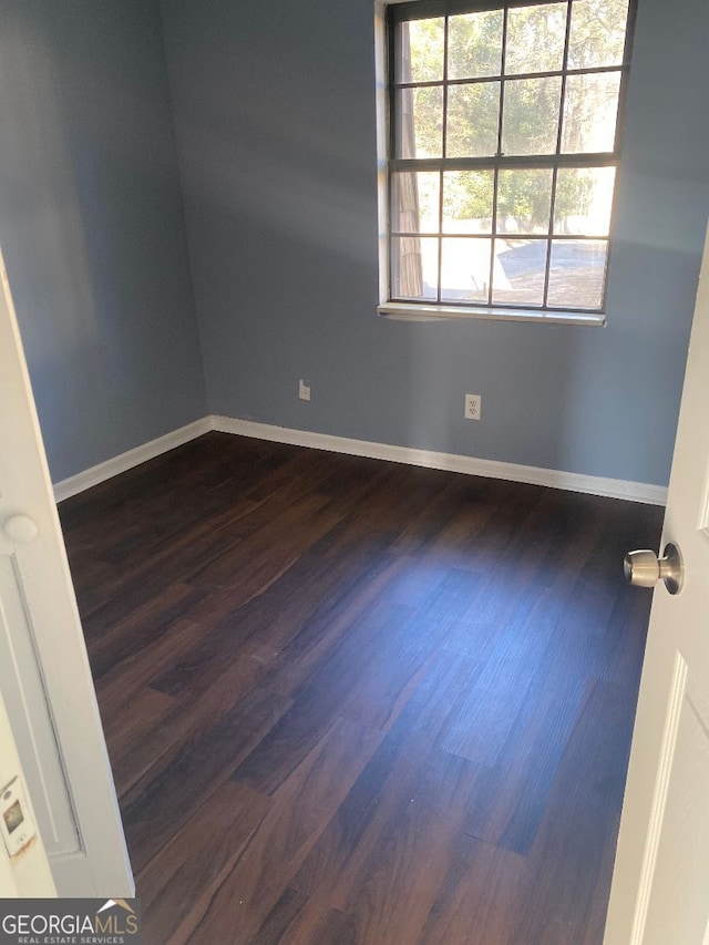 spare room with dark hardwood / wood-style flooring