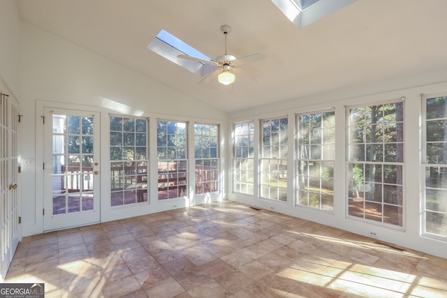 unfurnished sunroom with ceiling fan, plenty of natural light, and vaulted ceiling with skylight