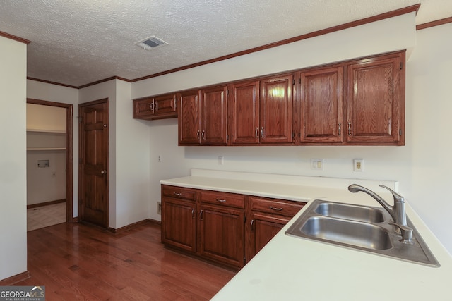 kitchen with a textured ceiling, dark hardwood / wood-style floors, ornamental molding, and sink