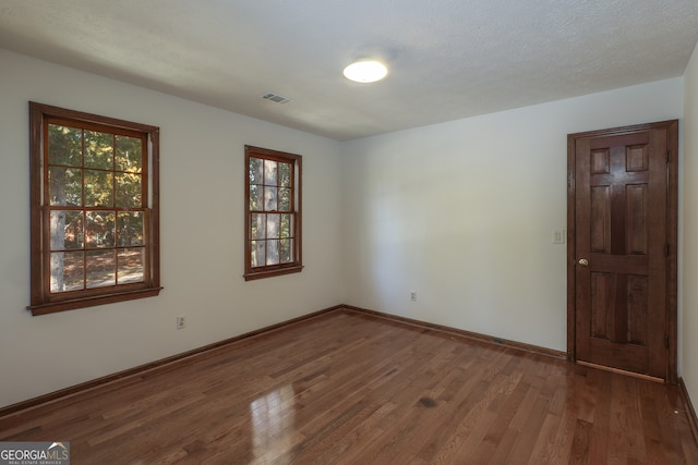 unfurnished room featuring hardwood / wood-style floors and a textured ceiling