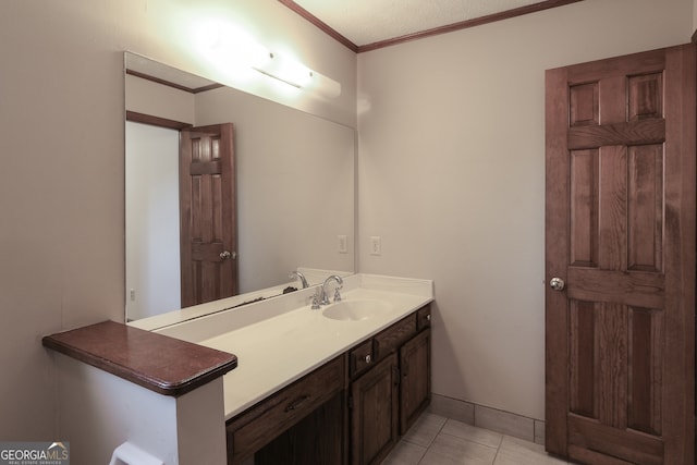 bathroom with tile patterned floors, vanity, ornamental molding, and a textured ceiling