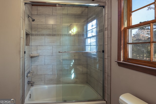 bathroom featuring shower / bath combination with glass door and toilet