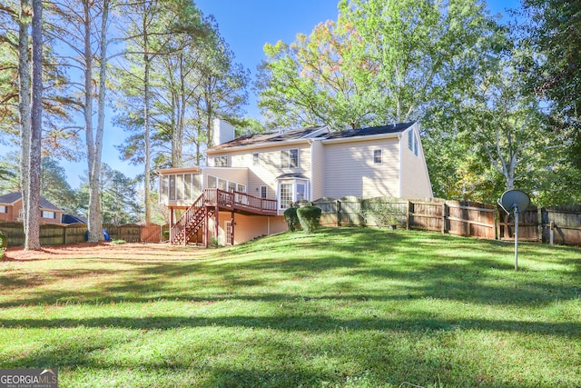 back of house with a lawn, a wooden deck, and a sunroom