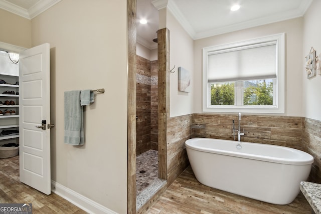 bathroom featuring hardwood / wood-style floors, independent shower and bath, crown molding, and tile walls