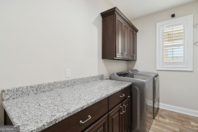 laundry area featuring light wood-type flooring, cabinets, and separate washer and dryer