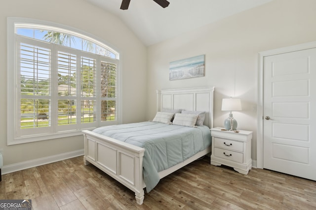 bedroom with light wood-type flooring, vaulted ceiling, and ceiling fan