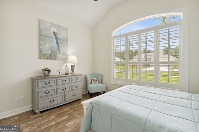 bedroom featuring light hardwood / wood-style flooring and lofted ceiling