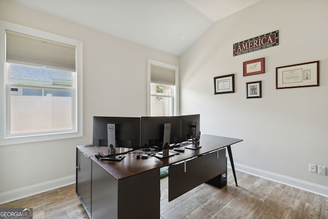 office space with light hardwood / wood-style flooring, vaulted ceiling, and plenty of natural light