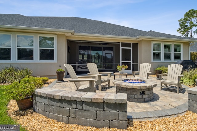 view of patio / terrace with a fire pit and a sunroom