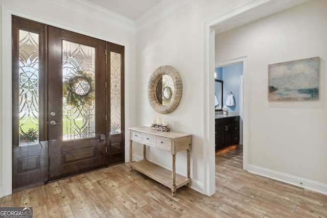 entrance foyer featuring ornamental molding, light wood-type flooring, and a wealth of natural light