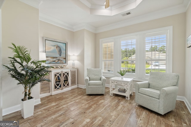 living area featuring light hardwood / wood-style flooring and crown molding