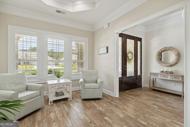 living area featuring hardwood / wood-style flooring and crown molding