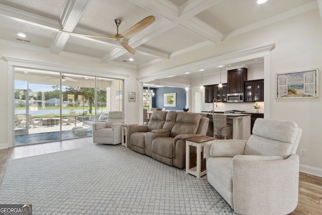 living room with ornamental molding, light wood-type flooring, beam ceiling, and coffered ceiling