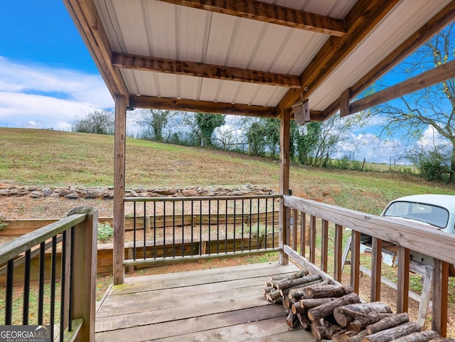 wooden deck with covered porch and a rural view