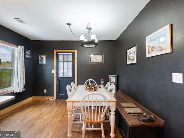 dining area featuring a notable chandelier and light wood-type flooring