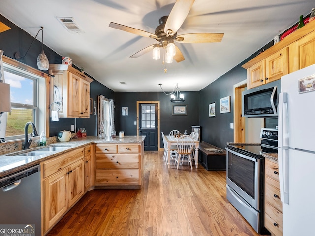 kitchen featuring light brown cabinets, sink, hanging light fixtures, kitchen peninsula, and stainless steel appliances