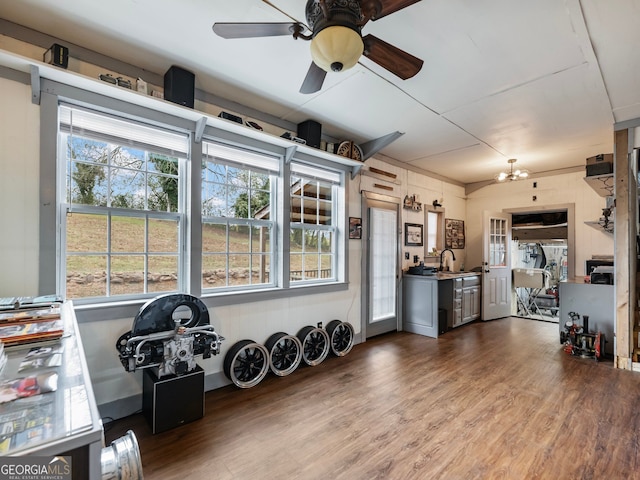 interior space with hardwood / wood-style floors, ceiling fan with notable chandelier, and sink