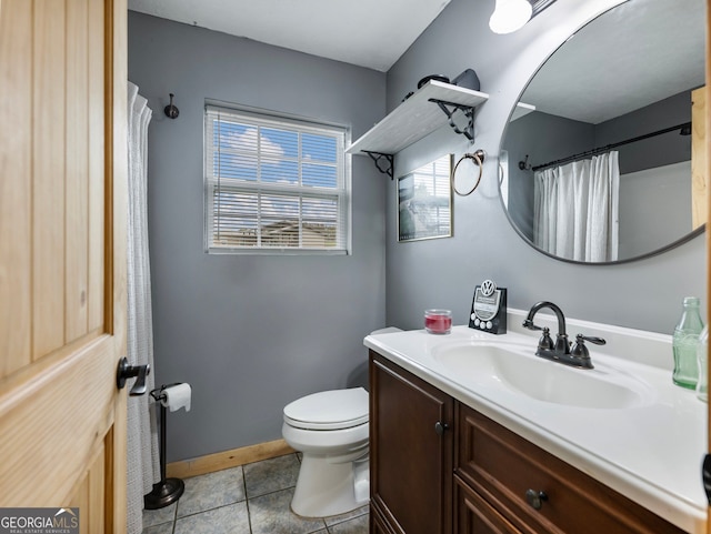 bathroom with toilet, vanity, and tile patterned floors