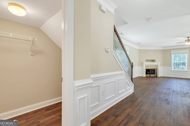 stairway with hardwood / wood-style floors, vaulted ceiling, ceiling fan, and crown molding