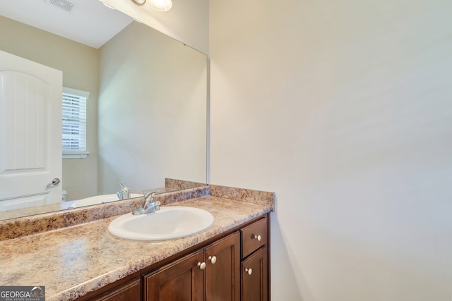 bathroom featuring toilet and vanity