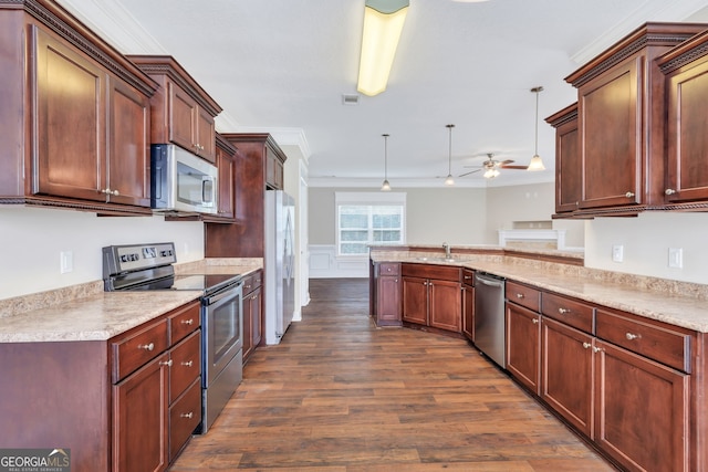 kitchen featuring kitchen peninsula, appliances with stainless steel finishes, ornamental molding, hanging light fixtures, and dark wood-type flooring