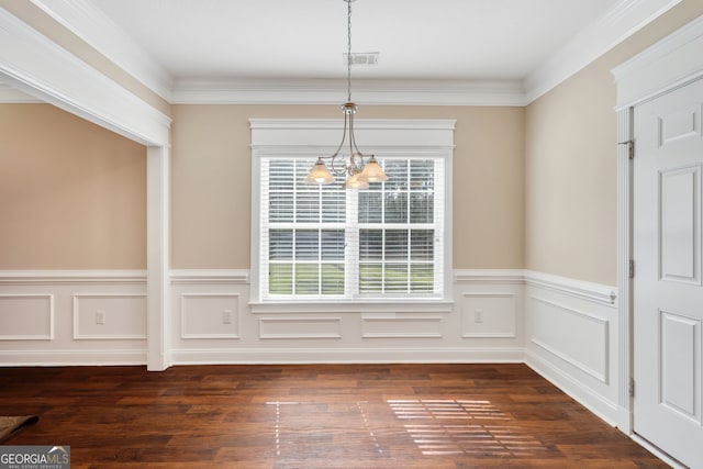 unfurnished dining area with dark hardwood / wood-style flooring, an inviting chandelier, and ornamental molding