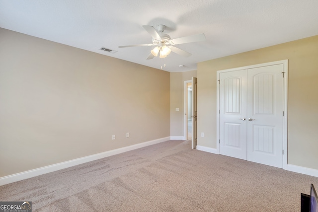 unfurnished bedroom with a closet, ceiling fan, and carpet floors