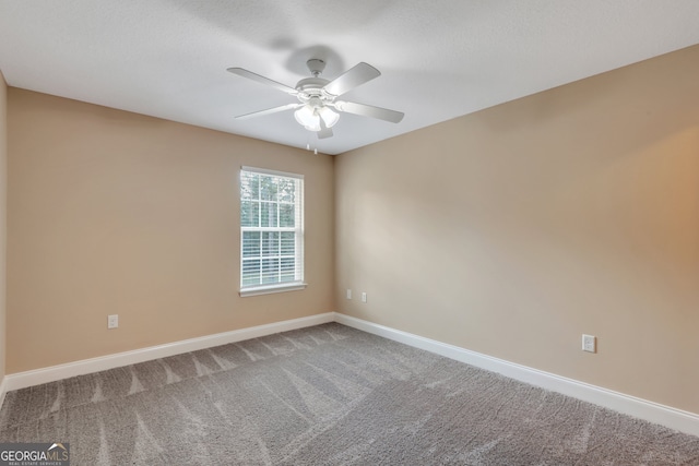 carpeted spare room with ceiling fan