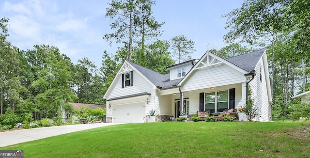 craftsman-style home with covered porch, a garage, and a front lawn