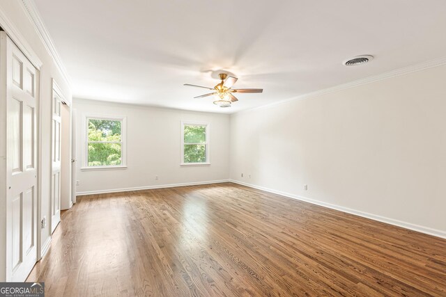 unfurnished bedroom with ceiling fan, crown molding, and wood-type flooring