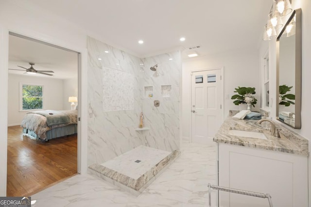 bathroom with tiled shower, vanity, and ceiling fan