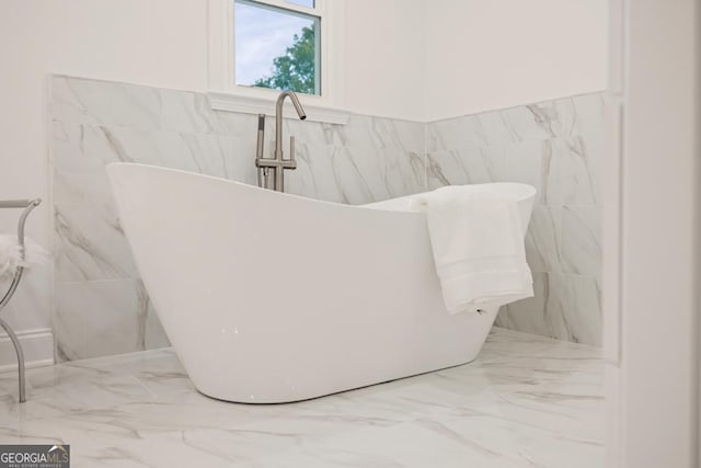 bathroom featuring tile walls and a tub