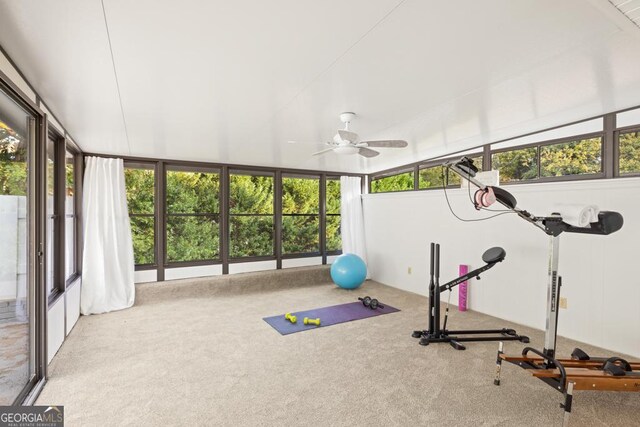 exercise area with ceiling fan, light colored carpet, and vaulted ceiling