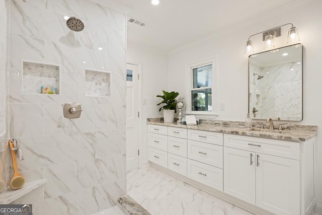 bathroom featuring vanity, ornamental molding, and tiled shower