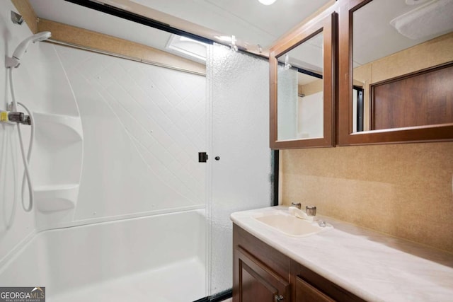 bathroom with walk in shower and vanity