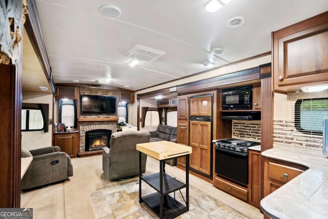 kitchen featuring crown molding, gas range, and a fireplace