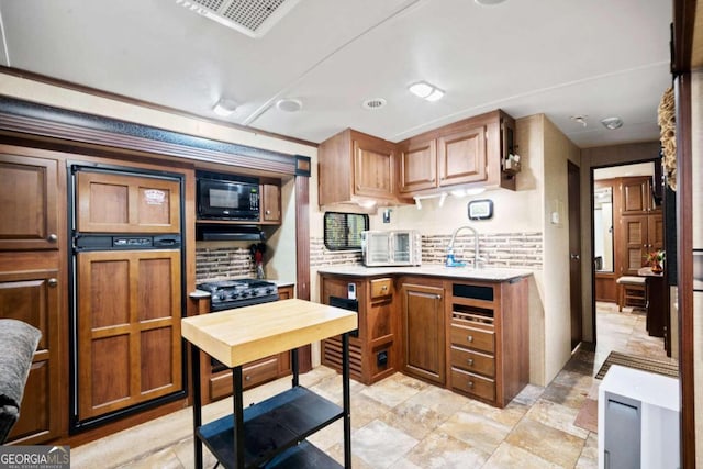 kitchen featuring black appliances and tasteful backsplash