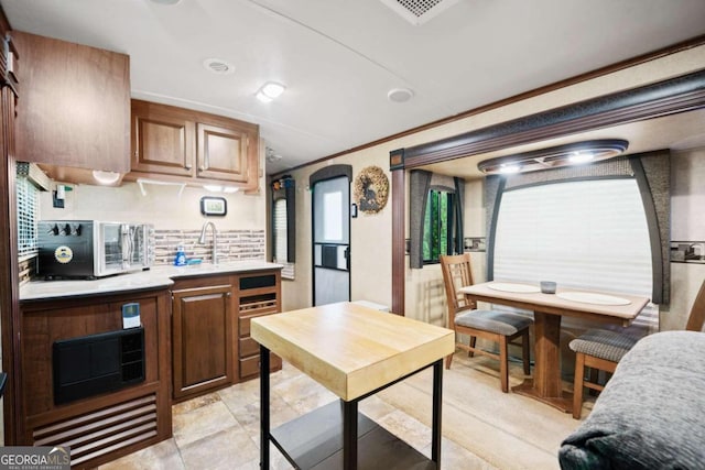 kitchen with sink, decorative backsplash, and crown molding