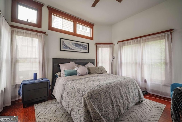 bedroom featuring dark hardwood / wood-style flooring, multiple windows, and ceiling fan