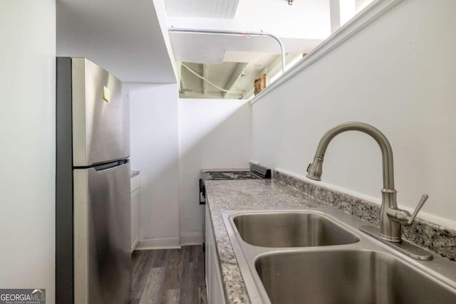 kitchen with dark hardwood / wood-style flooring, sink, and stainless steel fridge