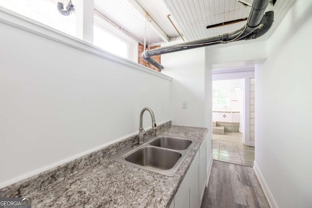 kitchen with light hardwood / wood-style flooring, sink, and white cabinets