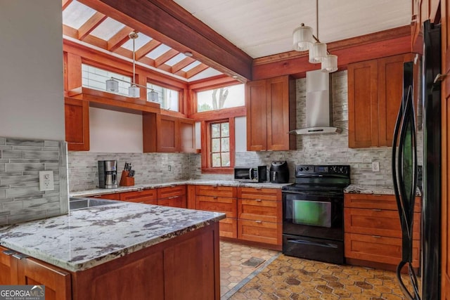 kitchen featuring decorative backsplash, black appliances, wall chimney range hood, light stone countertops, and pendant lighting