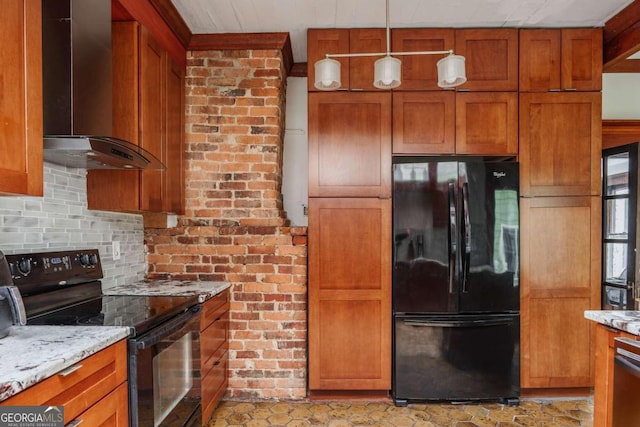 kitchen with pendant lighting, black appliances, wall chimney range hood, and light stone countertops