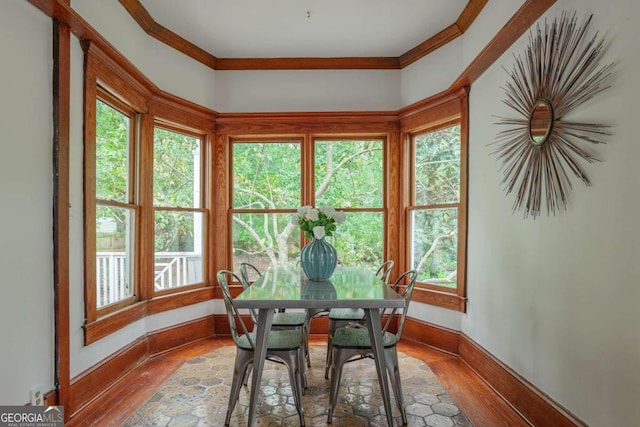 dining space with hardwood / wood-style floors and crown molding