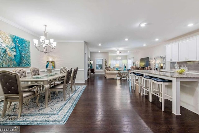 dining area featuring ceiling fan with notable chandelier, dark hardwood / wood-style flooring, and ornamental molding